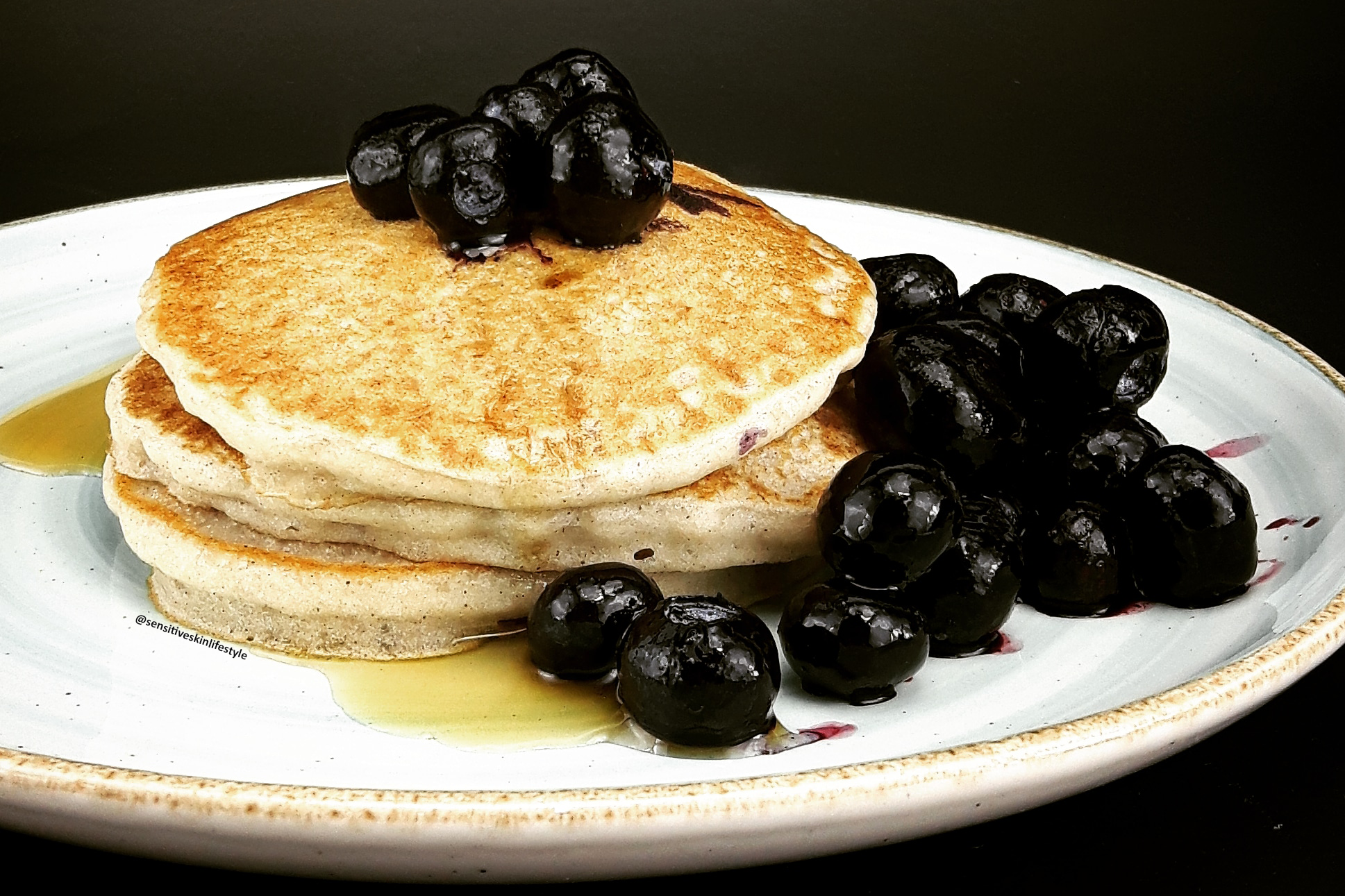 Side view photo of Catherine's home-made buckwheat pancakes with maple syrup and blueberries