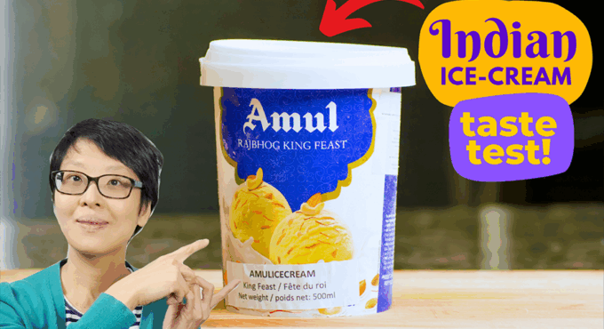 photo of the author of this post, pointing towards a 500mL Amul King Feast Rajbhog Ice Cream container. Text that says "Indian Ice Cream Taste Test" and an arrow also pointing to the ice cream.